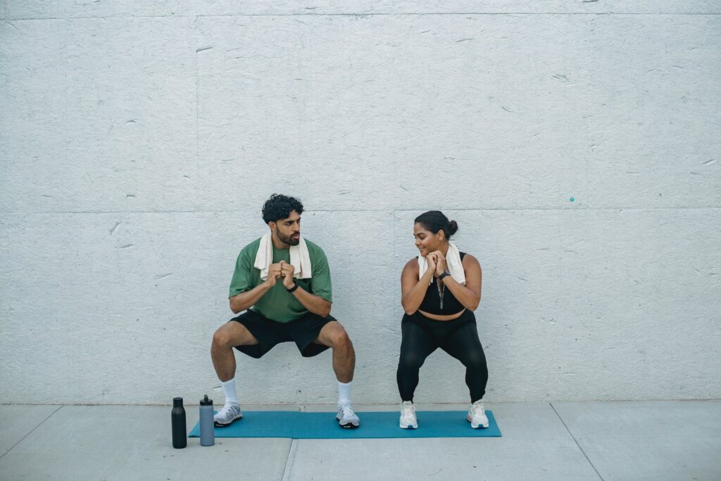 Man and Woman Doing Squats during a Workout