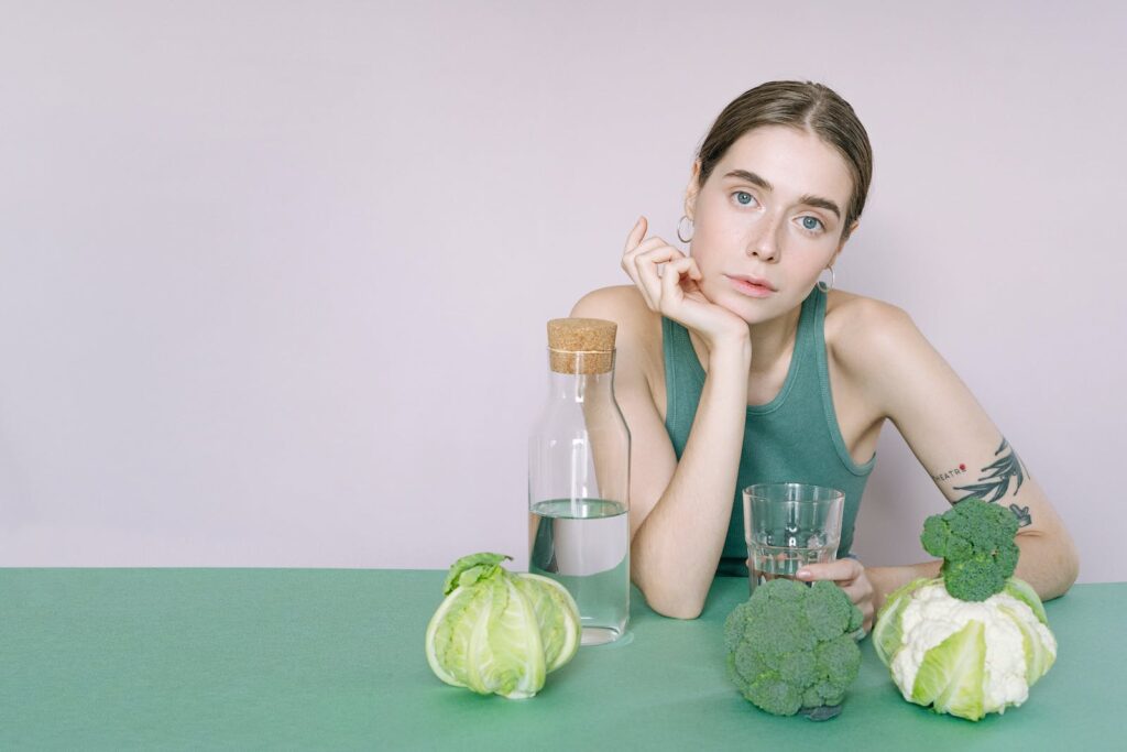 Woman in Green Tank Top Sitting on Green Table