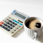 a cup of coffee next to a calculator